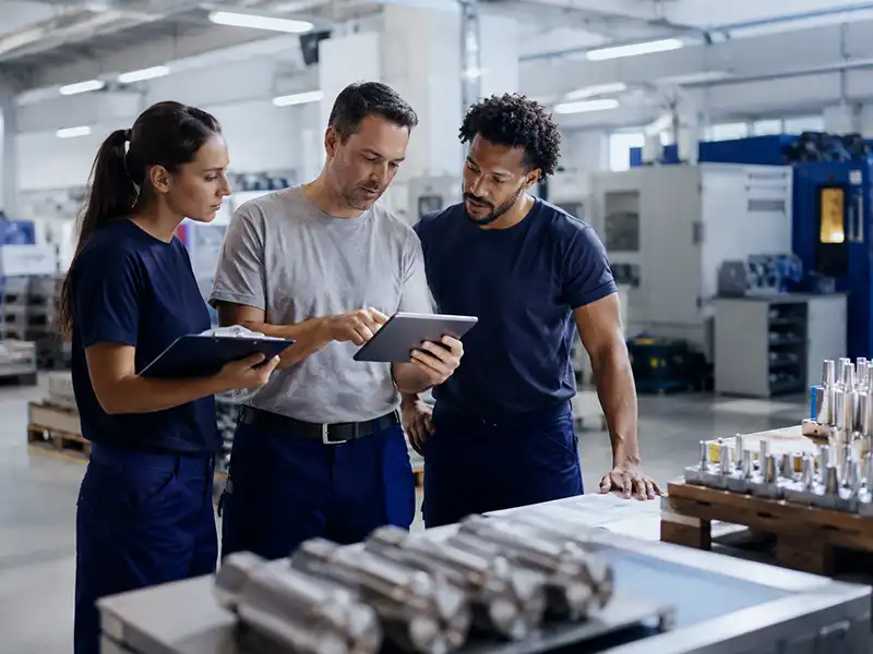 Equipe analisando dados de produção e fluxo operacional em uma fábrica